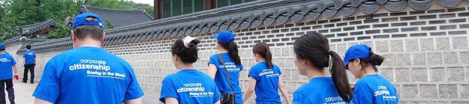 Group of people walking, wearing blue corporate citizenship t-shirts